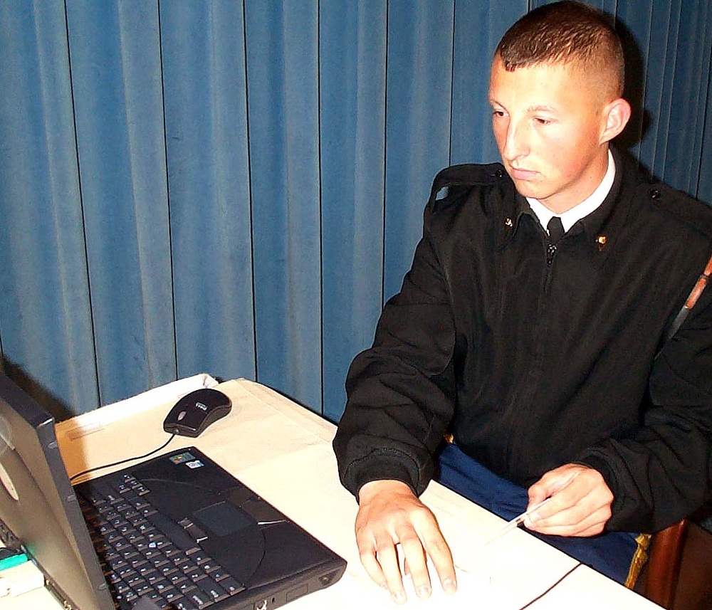 Soldier inserting CAC card into reader device