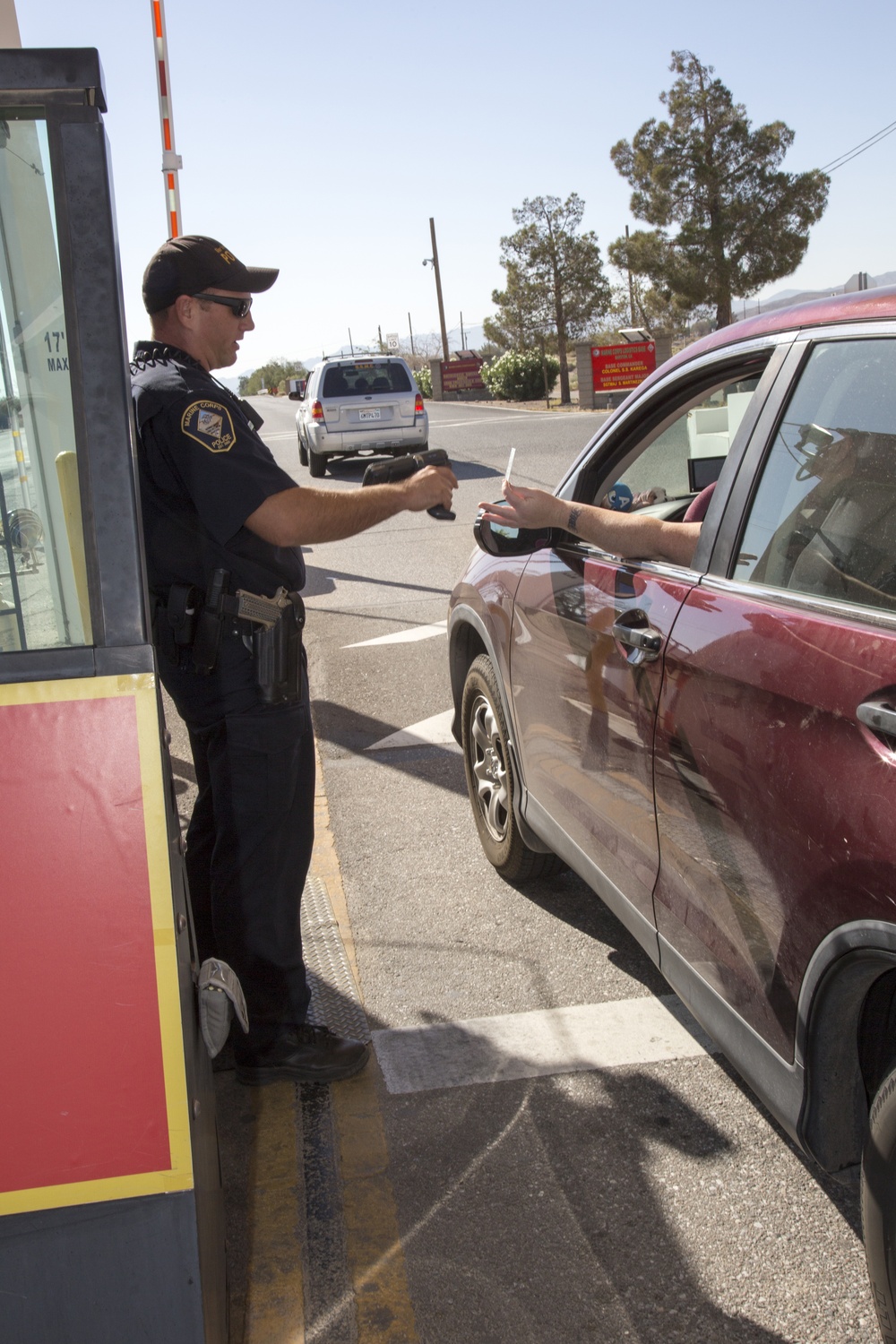 Police officer scanning Common Access Card at gate